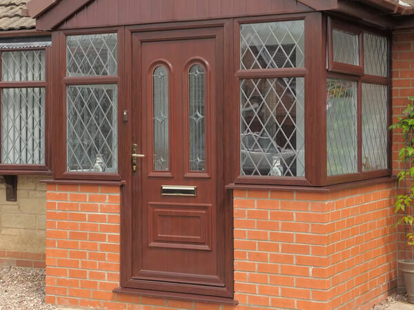 A Brick Porch With A Brown Door